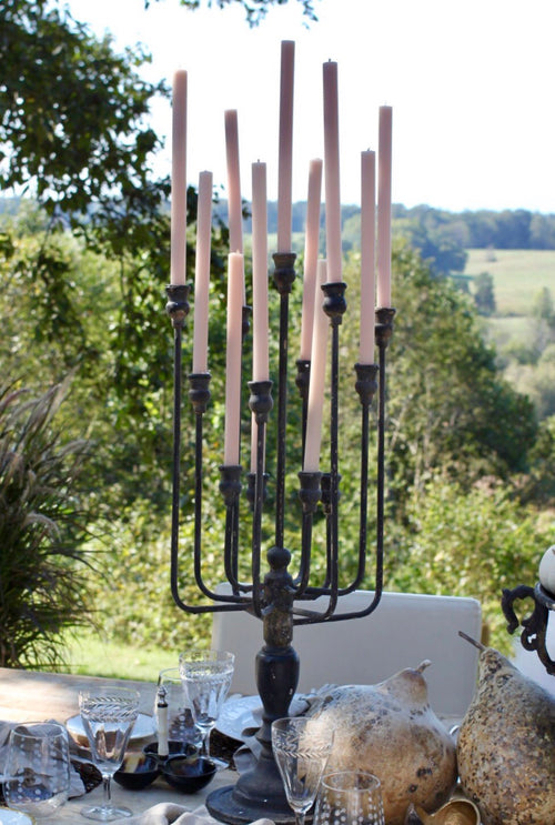 Antiqued iron candelabra centerpiece holding taper candles